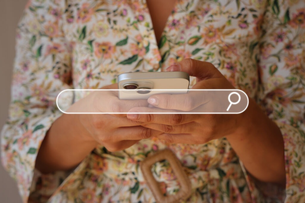 A person holding a phone and a search icon